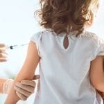 Un niño recibe la vacuna contra la gripe de un médico.