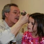 Un pediatra de Houston está examinando el oído de una niña.