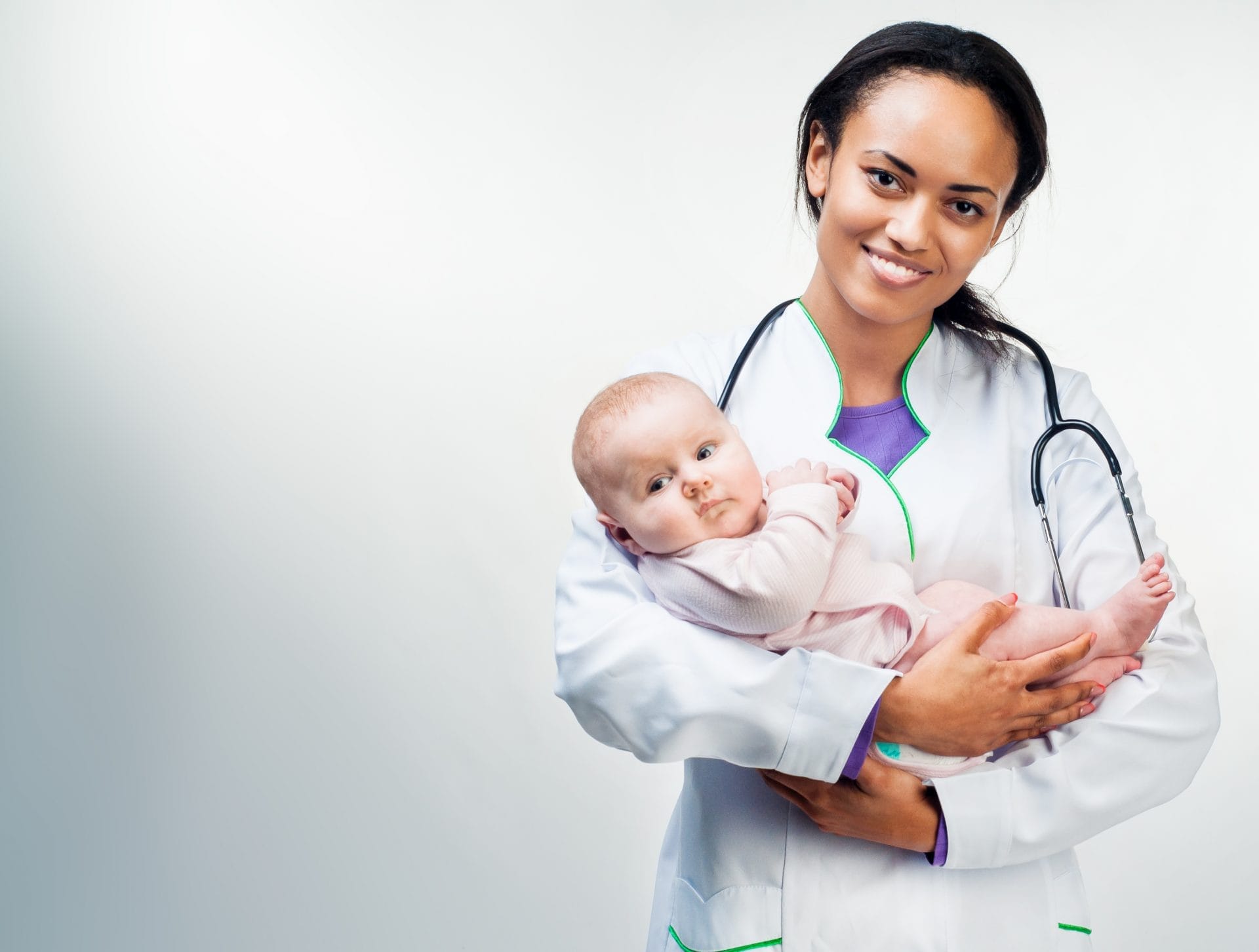 A woman holding a baby with a stethoscope.