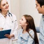 Un pediatra de Houston está realizando evaluaciones del desarrollo de una niña.