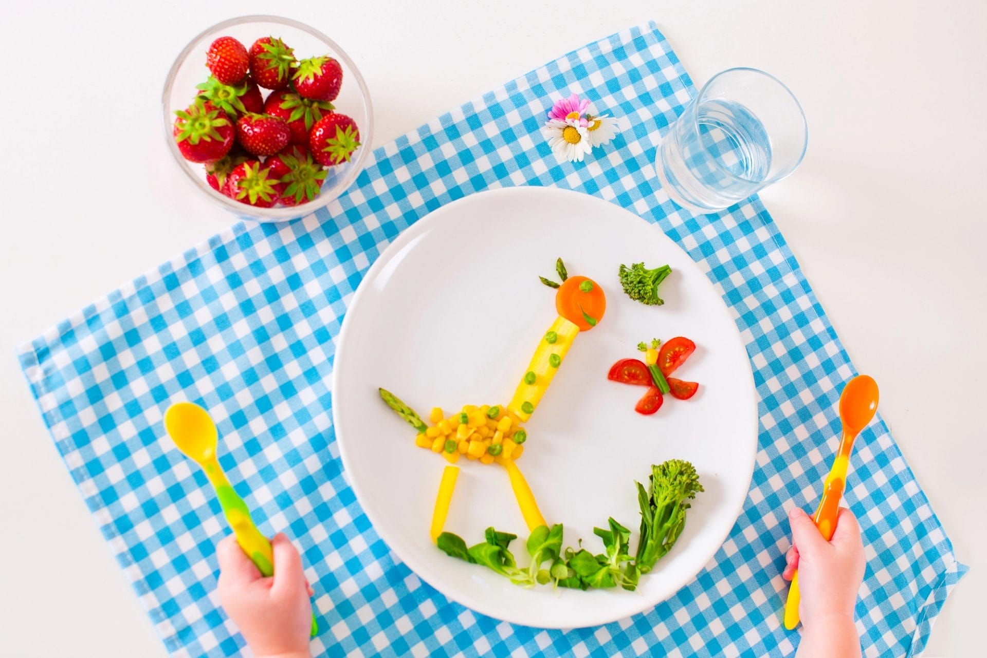 Un plato con una jirafa y fresas que proporciona nutrición experta a los niños.