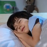 En un cuento infantil, un niño duerme plácidamente en su cama.