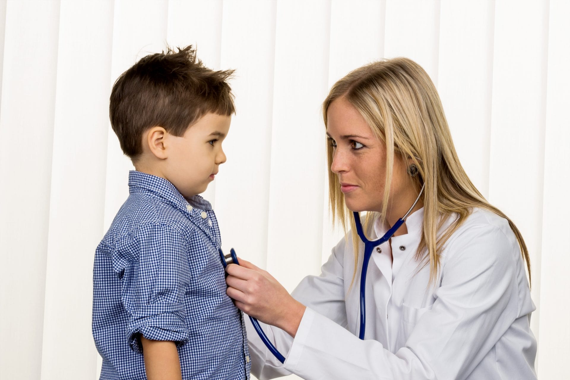 Un médico experto está examinando a un niño GameReady con un estetoscopio.