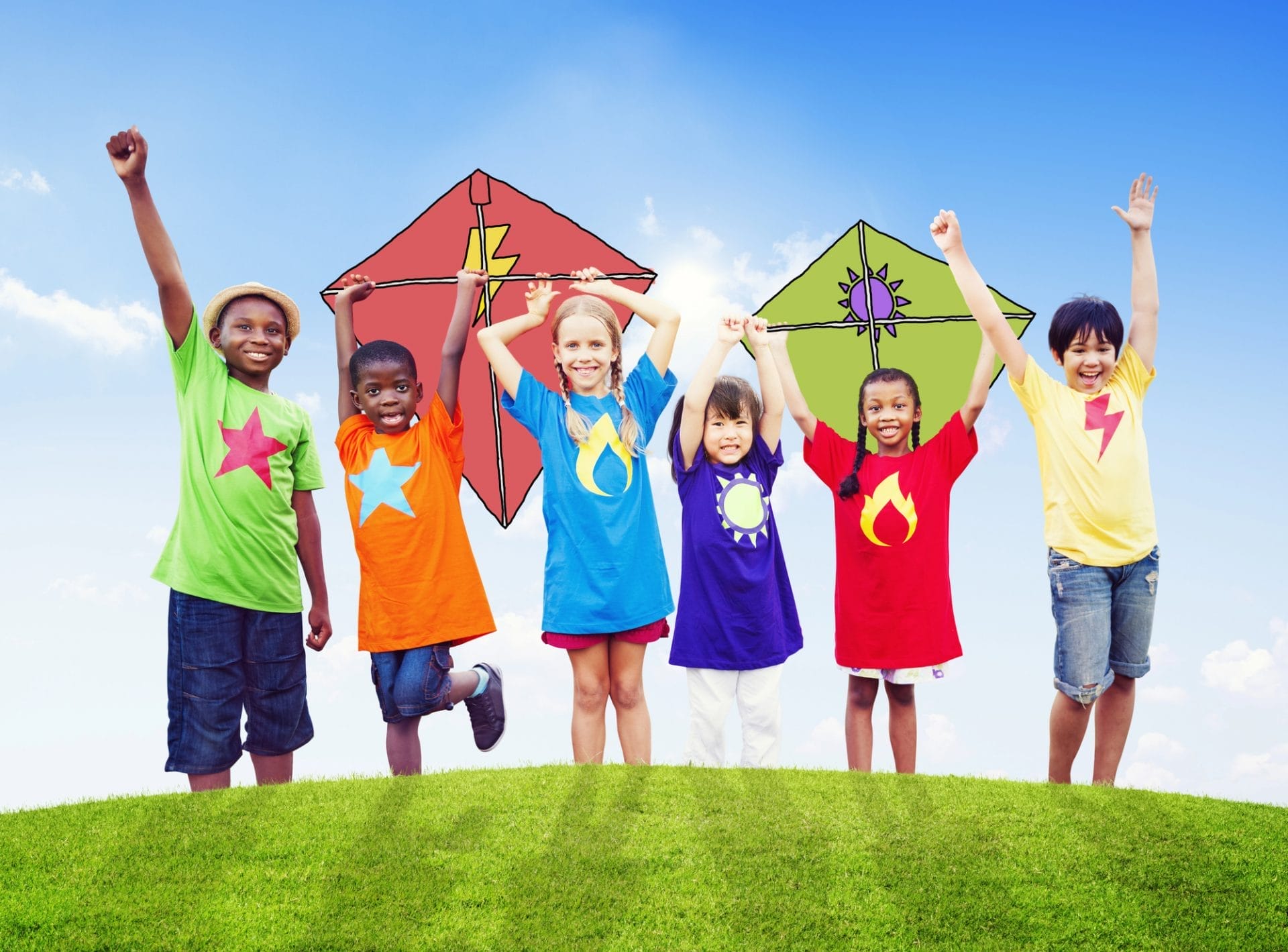 Six children wearing colorful t-shirts with symbols stand on grass, holding up kites and smiling under a blue sky, showing how families can help their kids make healthy choices through fun outdoor activities.