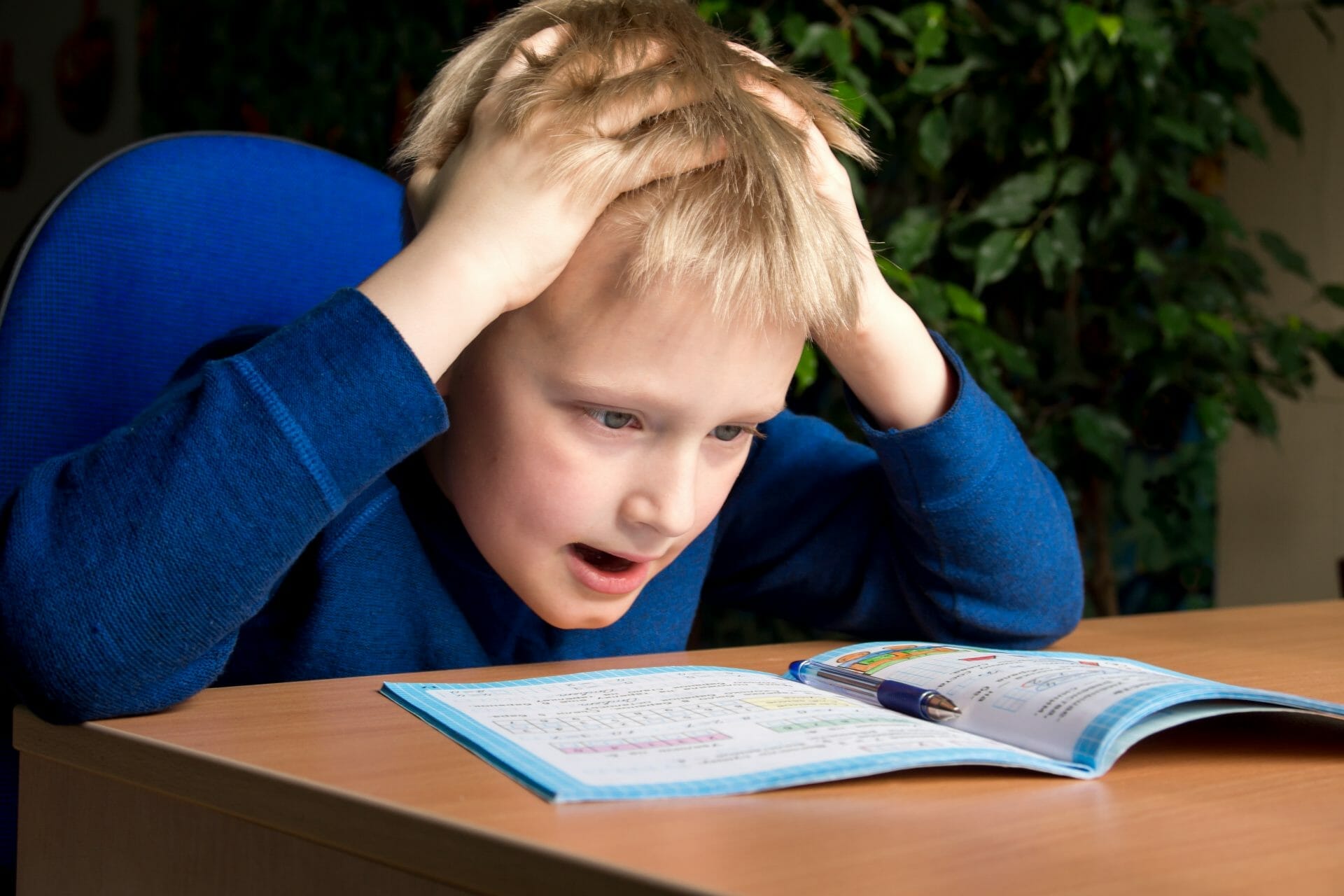 A boy is reading a book while maintaining good posture.